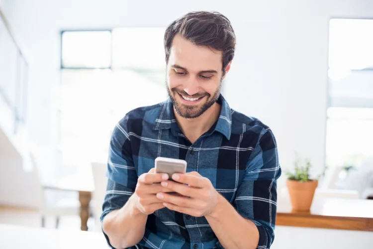 Smiling man checking phone messages