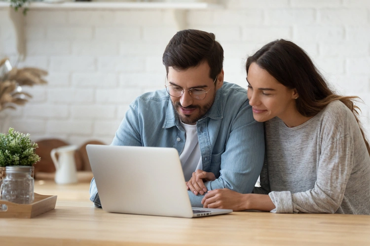 Couple looking at a laptop together at home