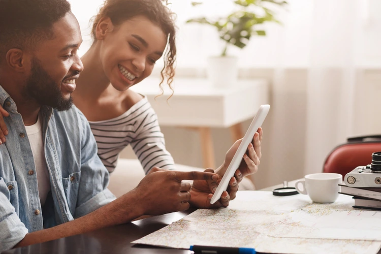 Couple looking at a tablet with paperwork on the table