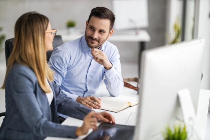 Two people discussing loan options in an office