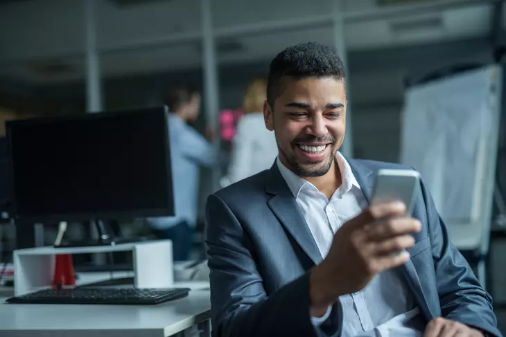 a businessman typing on a phone