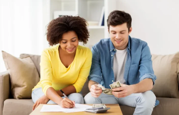 Couple reviews loan payments and counts cash at home