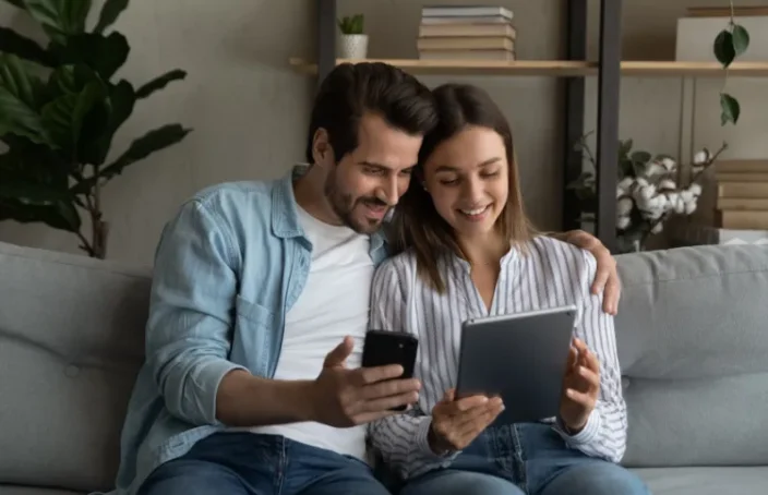 Couple comparing loan rates on a tablet and phone