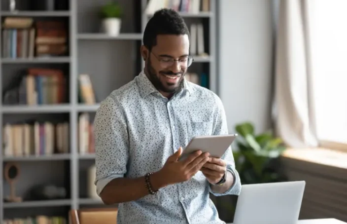 Man reviewing his credit progress on a tablet at home